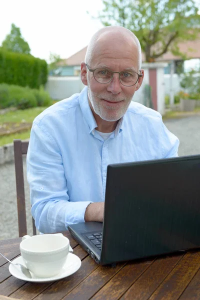 Senior man using a laptop outside — Stock Photo, Image