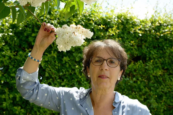 彼女は庭の花にで年配の女性 — ストック写真