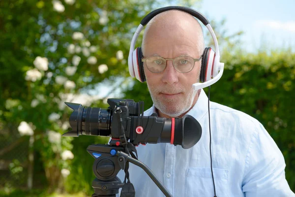 Mannen med hörlurar, med en dslr-kamera — Stockfoto