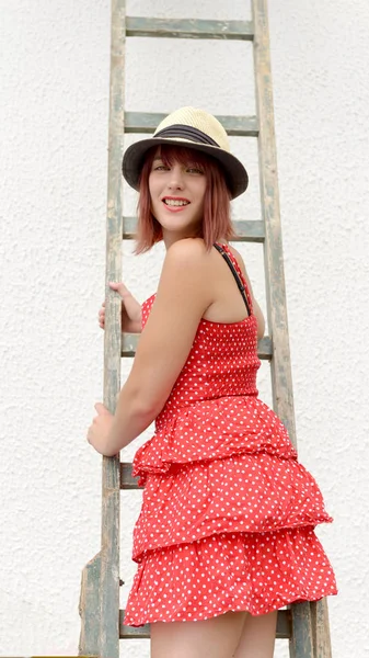 Beautiful girl climbing on a ladder — Stock Photo, Image