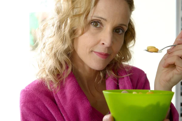 Jonge blonde vrouw granen eten in de ochtend — Stockfoto