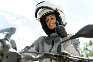  Kız bir motosiklet üzerinde oturur ve kafasında kask vardır