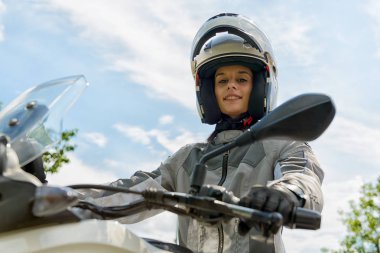  Kız bir motosiklet üzerinde oturur ve kafasında kask vardır