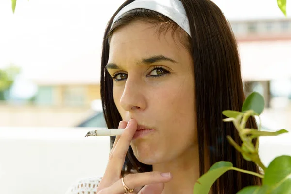 Mujer joven fumando un cigarrillo — Foto de Stock