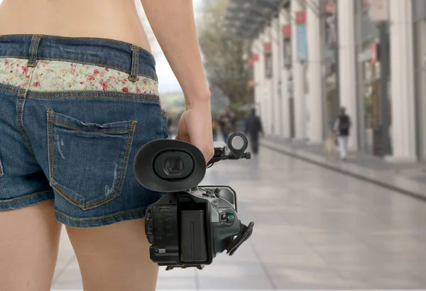 Оператор девушка держит свою профессиональную видеокамеру на улице — стоковое фото