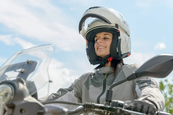 Jente sitter på motorsykkel og har hjelm på hodet – stockfoto