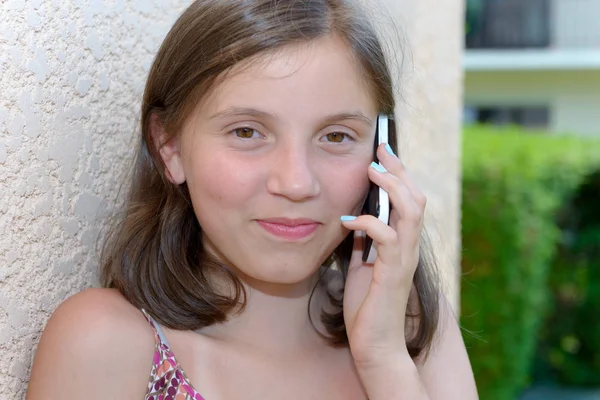 Lachende pre tiener meisje bellen op smartphone, buiten — Stockfoto