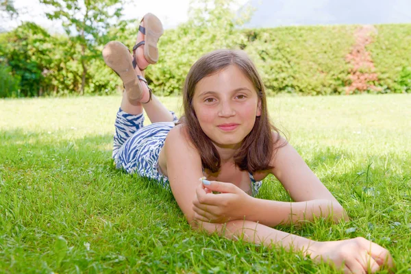 Belle pré adolescente couché dans l'herbe — Photo