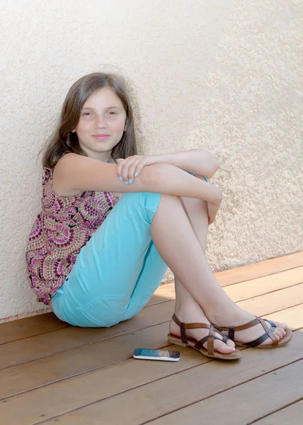 Mädchen mit glatten langen Haaren sitzt auf dem Boden. — Stockfoto