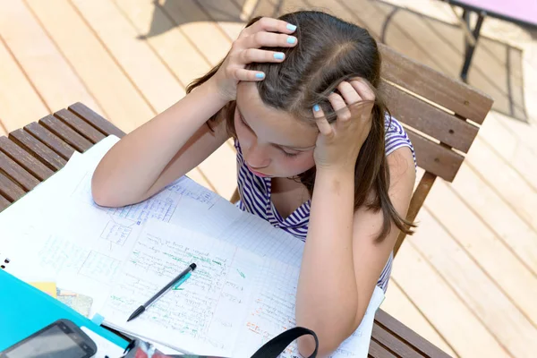 Znuděný dospívající dívka dělá její domácí úkoly — Stock fotografie