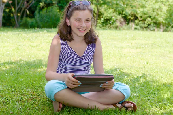 Mooie lachende tiener met tablet pc, buitenshuis — Stockfoto