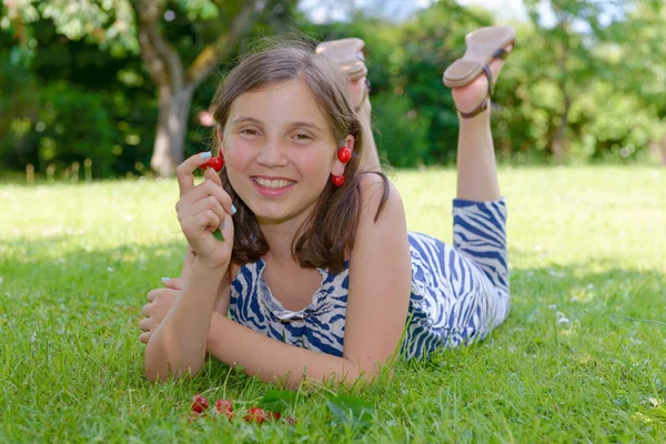 Ganska tonårig flicka utomhus med körsbär — Stockfoto