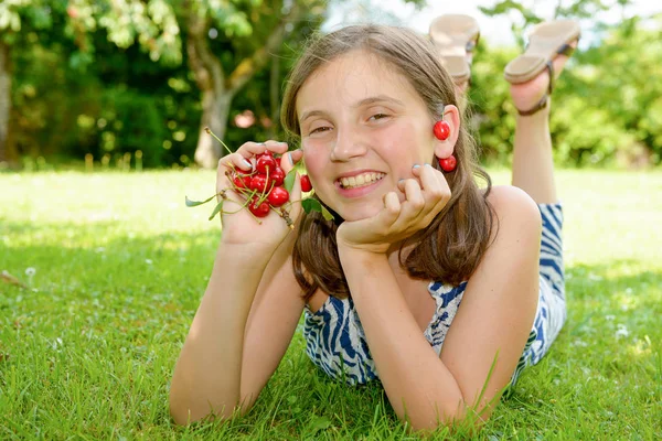 Docela dospívající dívka venku s cherry — Stock fotografie