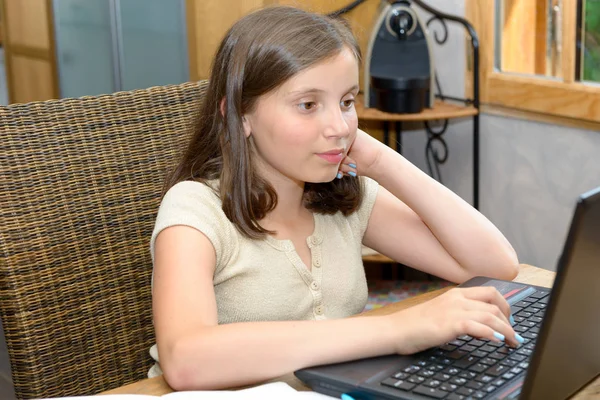 Joven adolescente chica haciendo su tarea con portátil — Foto de Stock