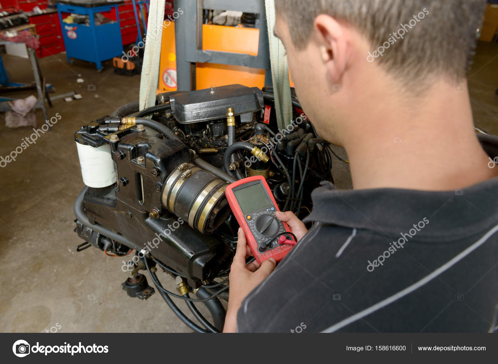 Mechanic man with digital multimeter testing ignition coil — Stock