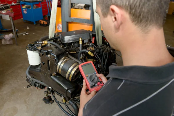 Mechanik muž s digitální multimetr testování zapalovací cívky — Stock fotografie