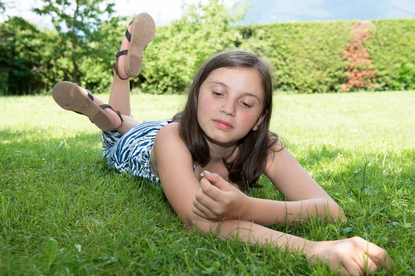 Hermosa chica pre adolescente tendida en la hierba —  Fotos de Stock