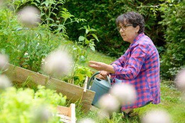 Olgun kadın onu bahçede çalışıyor