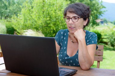 Modern casual kadın Garden'da laptop ile oturuyordu