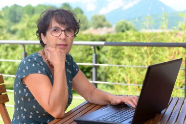 Modern casual kadın Garden'da laptop ile oturuyordu