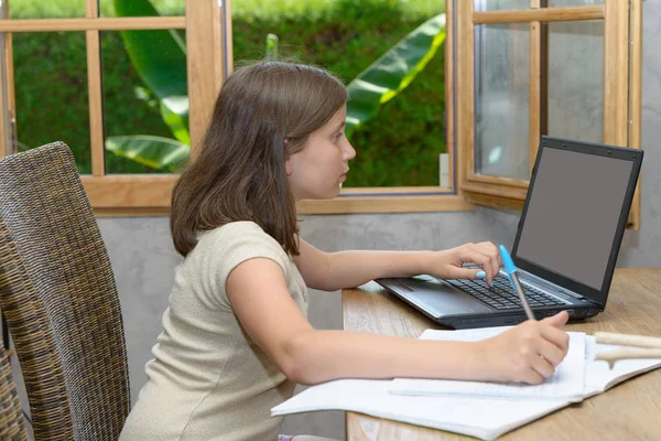 Adolescente fazendo seu dever de casa com laptop — Fotografia de Stock