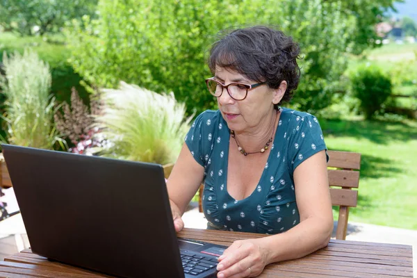 Modern alkalmi nő ül a kertben, laptop — Stock Fotó