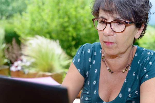 Modern alkalmi nő ül a kertben, laptop — Stock Fotó
