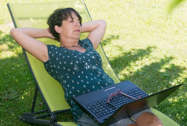 Bahçe şezlong üzerinde rahatlatıcı mutlu olgun kadın