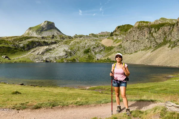 En kvinna vandring nära en fjällsjö — Stockfoto