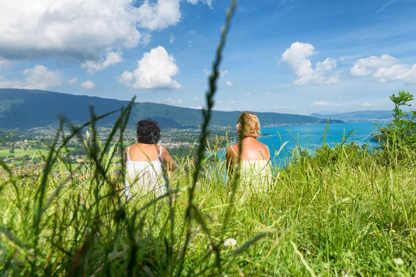 Två kvinnor titta på vyn över sjön Annecy — Stockfoto