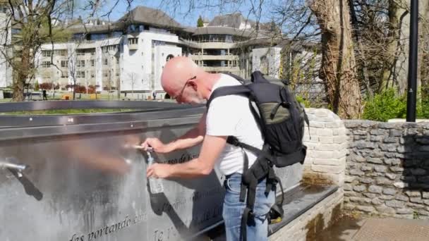 Mann trinkt Wasser aus Lourdes-Quelle in französischen Pyrenäen — Stockvideo