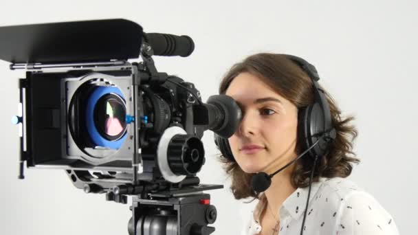 Bella giovane donna con videocamera DSLR e cuffie — Video Stock