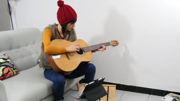 Молодая брюнетка с гитарой и планшетом — стоковое видео