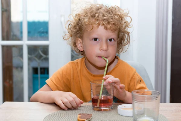 Söt liten pojke dricka röd saft med sugrör — Stockfoto