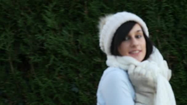Молодая брюнетка в зимнем колпаке на улице — стоковое видео