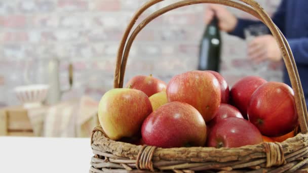 Man häller ett glas av Normandie cider, korg med äpplen i förgrunden — Stockvideo