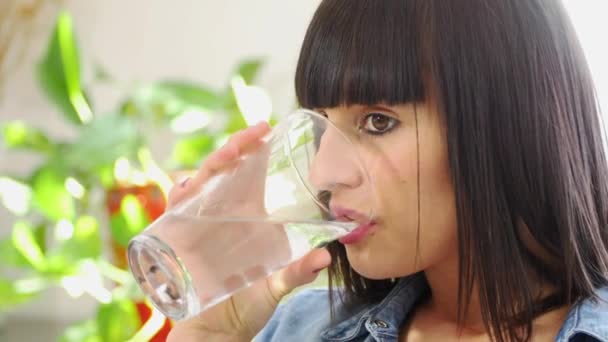 Krásná mladá brunetka žena pije sklenici vody — Stock video