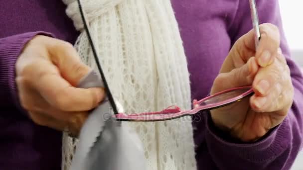 Vrouw reinigen de bril met een tissue, close-up — Stockvideo