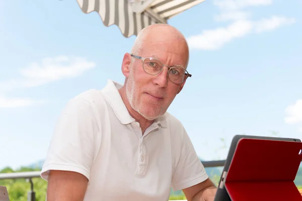 Hombre maduro utilizando tableta ordenador en la terraza , — Foto de Stock