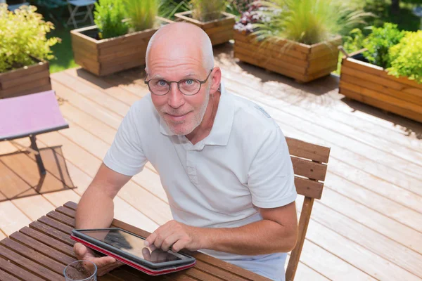 Hombre maduro utilizando tableta ordenador en la terraza , —  Fotos de Stock