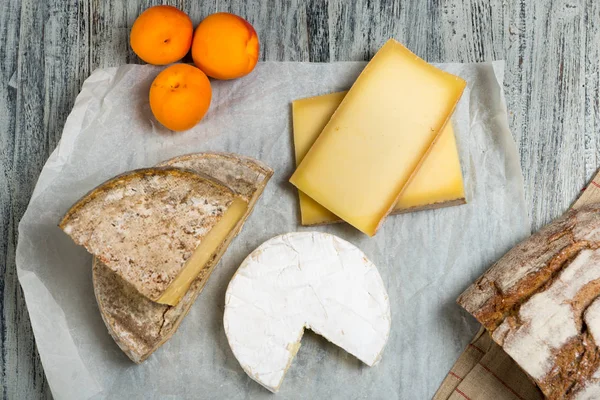Différents fromages français avec pain et abricots — Photo