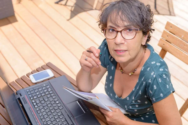 Alkalmi érett nő ül a laptop rendelkező terasz-kert — Stock Fotó