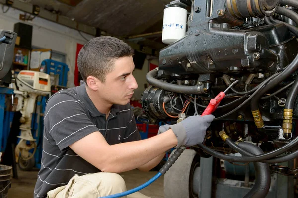 年轻的机修工清洗用压缩空气发动机 — 图库照片