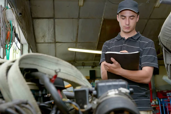 Un mecánico que compruebe el motor — Foto de Stock