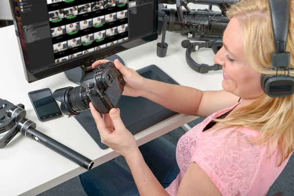 Fotógrafa joven rubia que trabaja con ordenador y gráficos —  Fotos de Stock