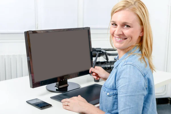 Młody projektant graficzny działa na komputerze za pomocą tabletu — Zdjęcie stockowe