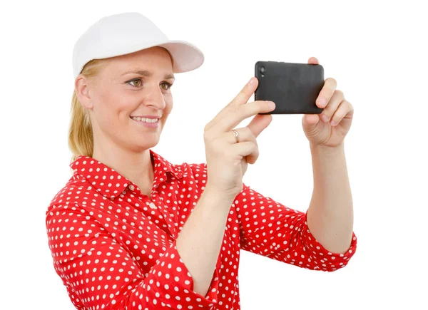 Улыбающаяся женщина фотографирует на камеру смартфона — стоковое фото