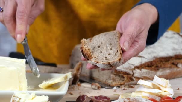 A woman's hand putting butter on a bread — Stock Video