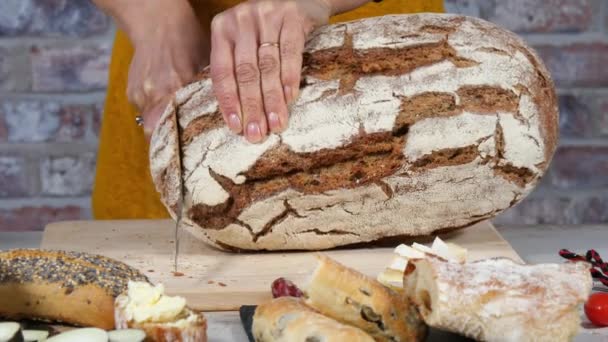 Woman hands cuts a traditional bread slice — Stock video