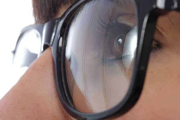 Gros plan d'un oeil de femme avec des lunettes noires — Photo